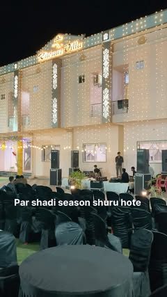 A lit-up venue with black-draped seating