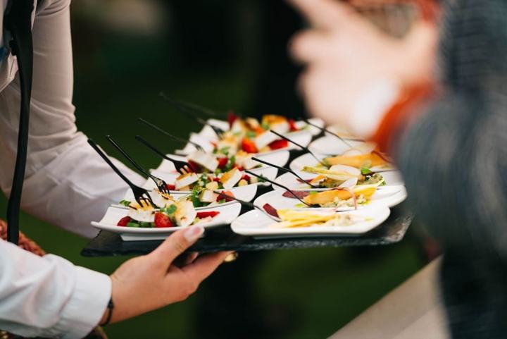 A server carrying a tray of plated canapés