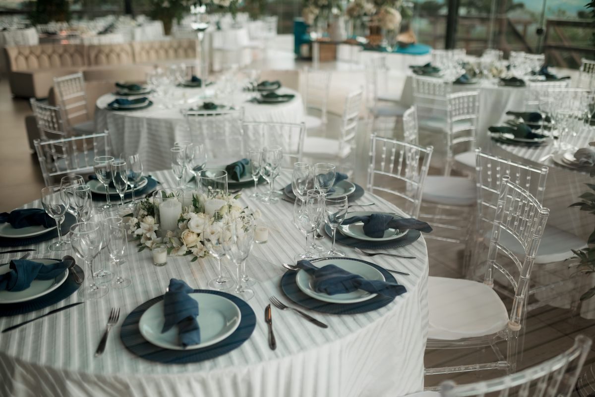 Banquet tables set with white linen and dark plates
